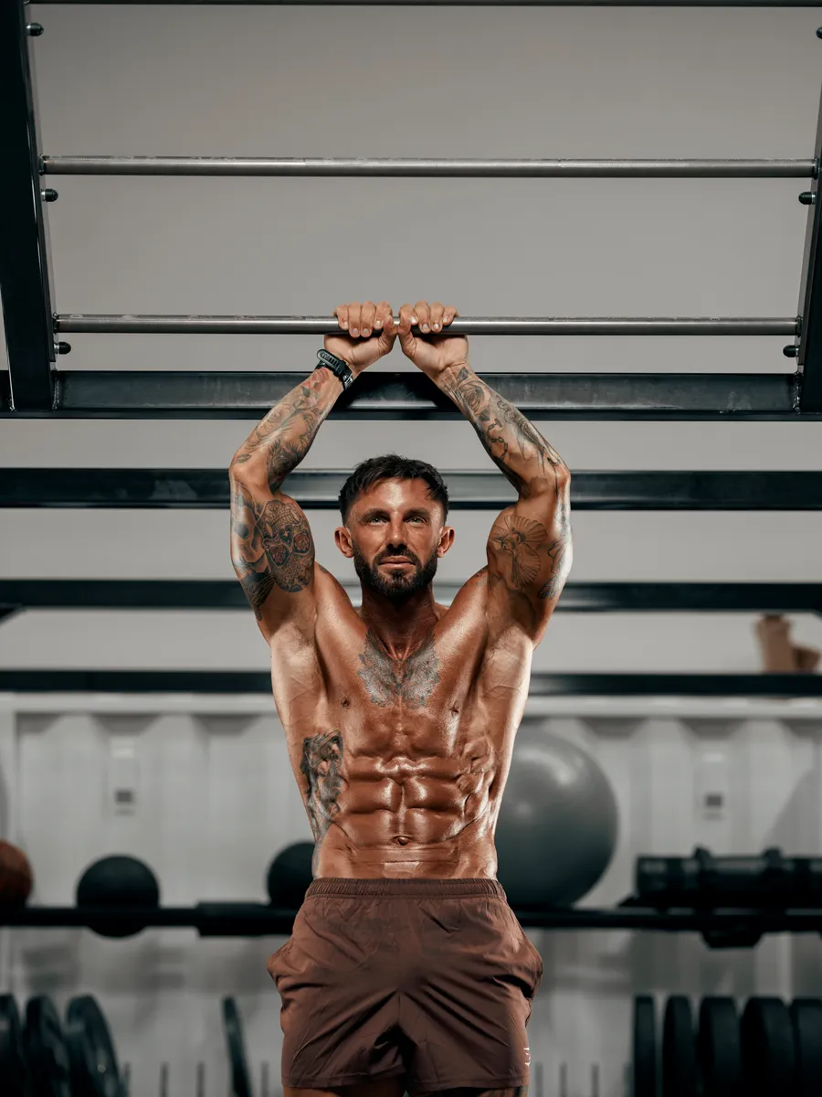Gripping a pull-up bar overhead, front view